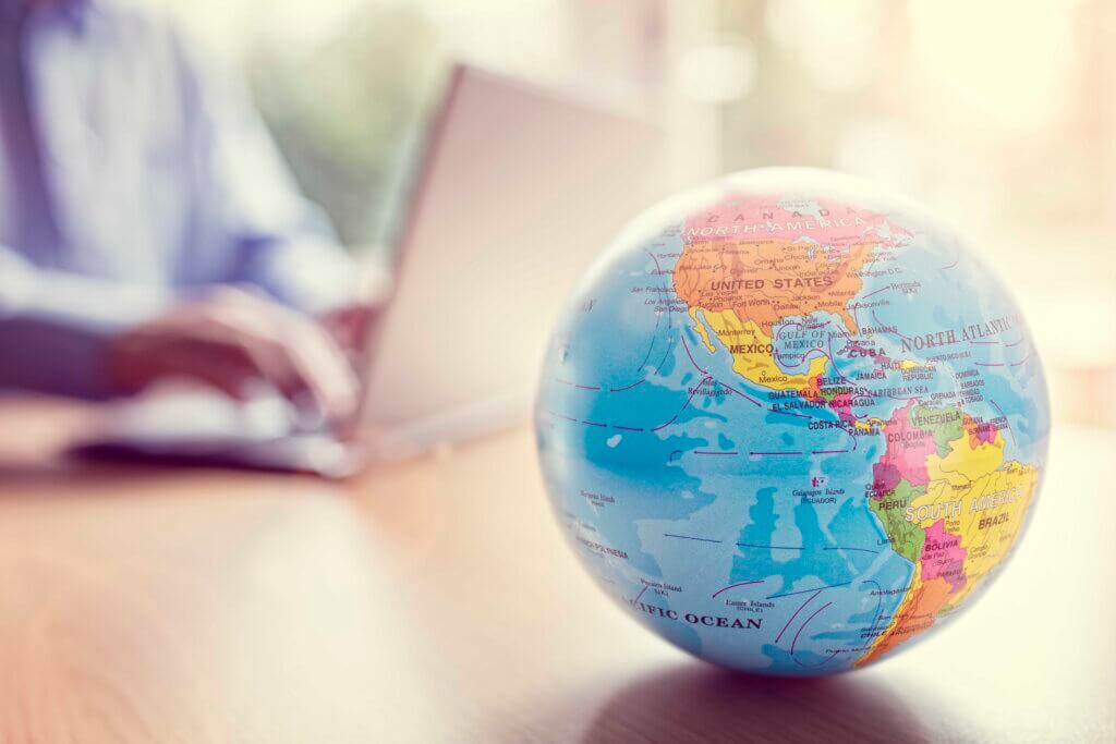 Businessman using a laptop with close up on world globe