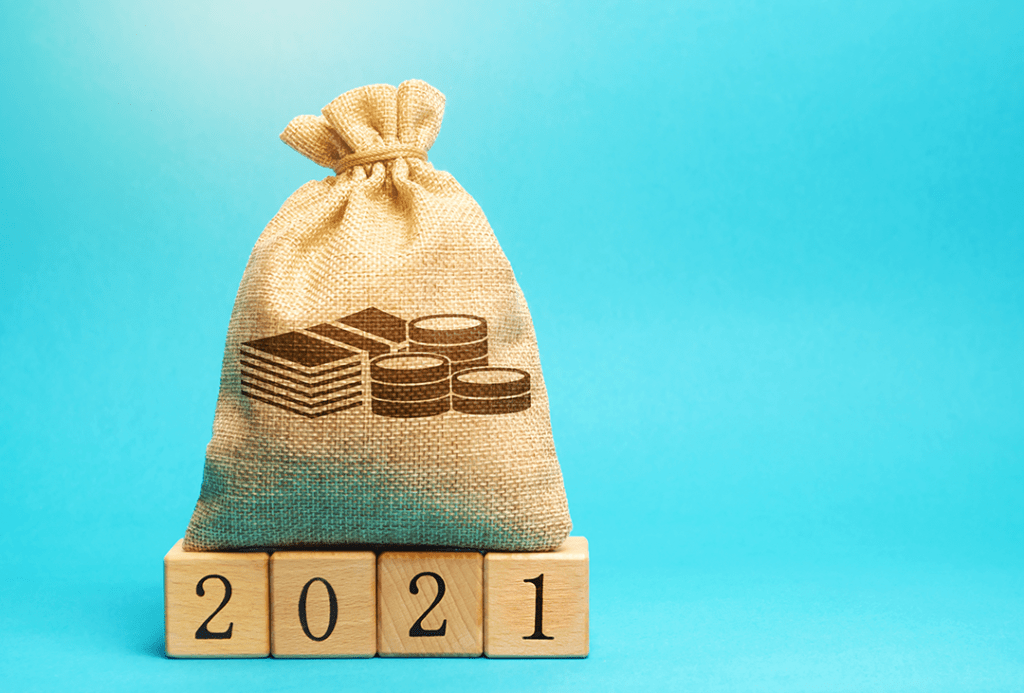 A burlap sack with bills and coins shown on the front sitting on four wooden blocks that say 2021.